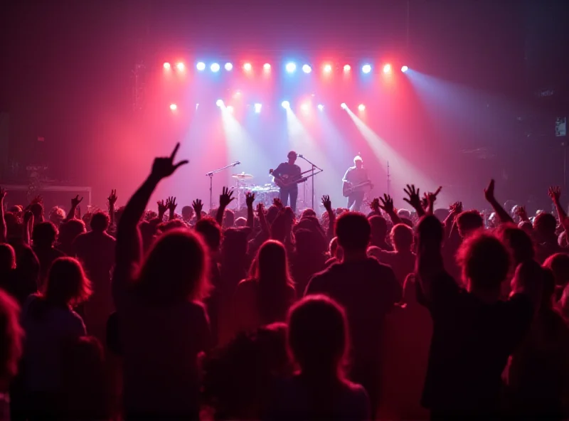 A crowded concert with a band performing on stage, lit by bright lights.