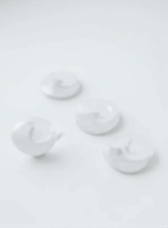 Close-up of four Apple AirTags arranged on a table, highlighting their sleek design and the promise of tracking valuables.