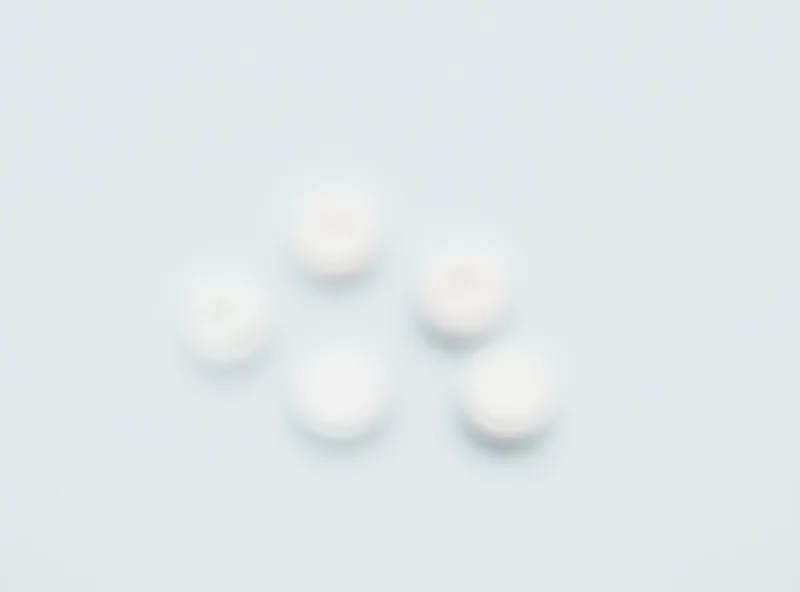 Aspirin pills arranged in a pattern on a white surface.