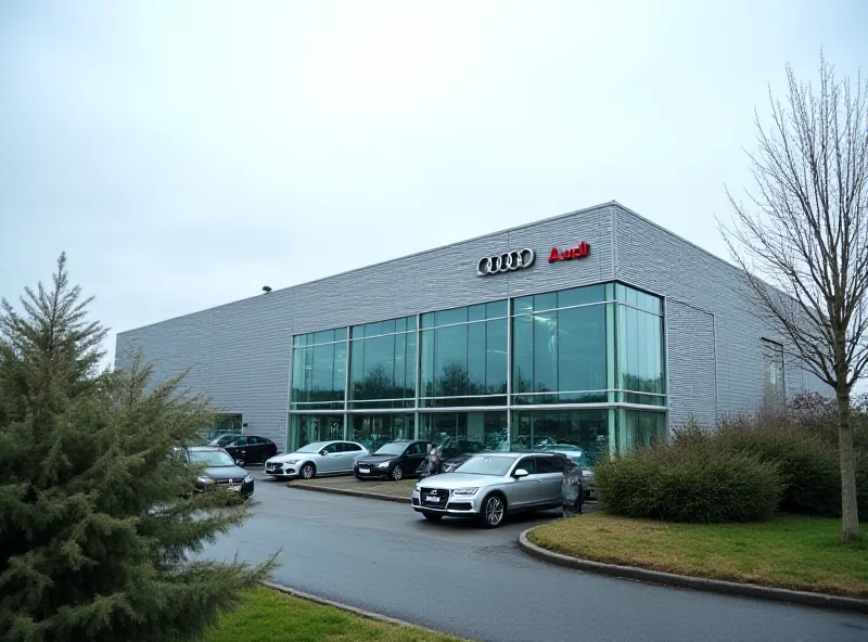 Exterior view of the Audi factory in Brussels. The factory is a large, modern industrial building with the Audi logo prominently displayed.