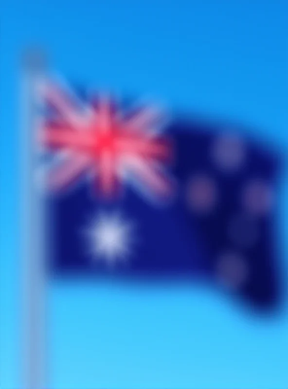 Australian flag waving in the wind against a clear blue sky