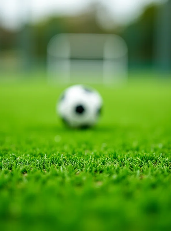 Close up of a soccer ball rolling on a green synthetic turf field, with blurred background.