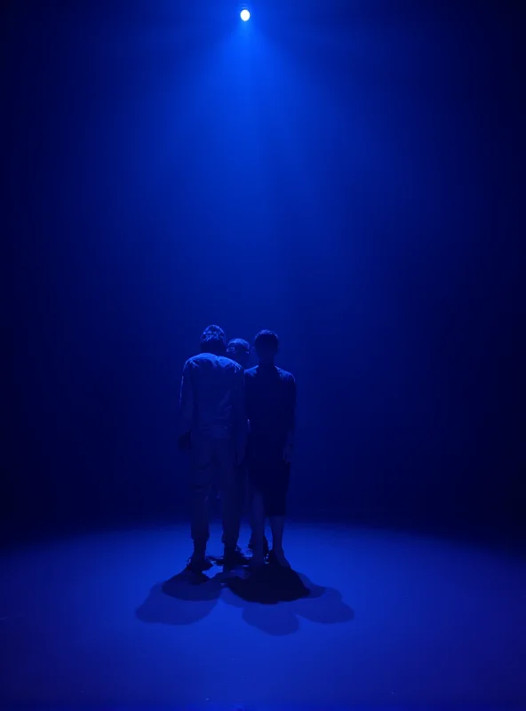 A scene from a modern dance performance with dramatic lighting.