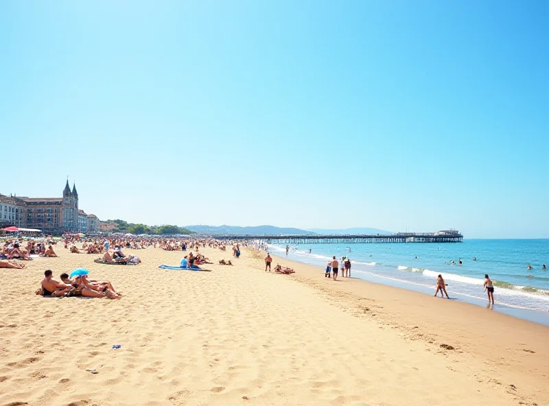 A sunny day at Bournemouth beach with people sunbathing and swimming.