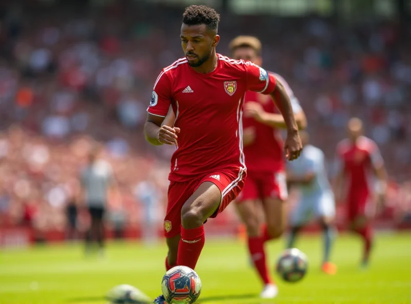 A soccer player in a red and white jersey dribbling a soccer ball during a game.