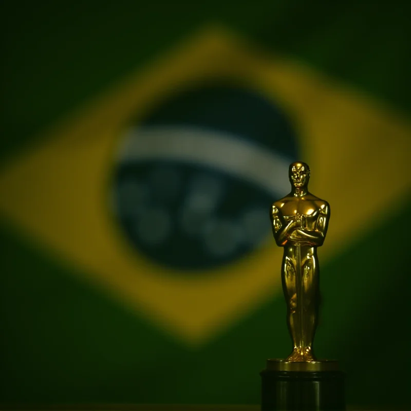 Oscar statue with Brazilian flag in the background