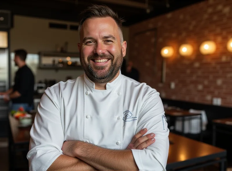 Byron Gomez, a smiling chef in his chef's whites, standing in his restaurant, Bruto, in Denver, Colorado.