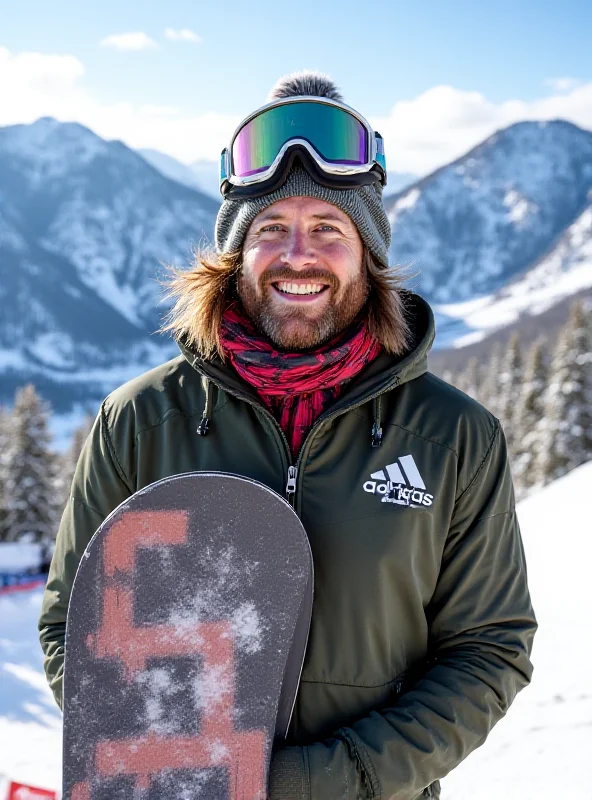 Shaun White, smiling and holding a snowboard, standing against a backdrop of snow-covered mountains and a halfpipe snowboarding course.