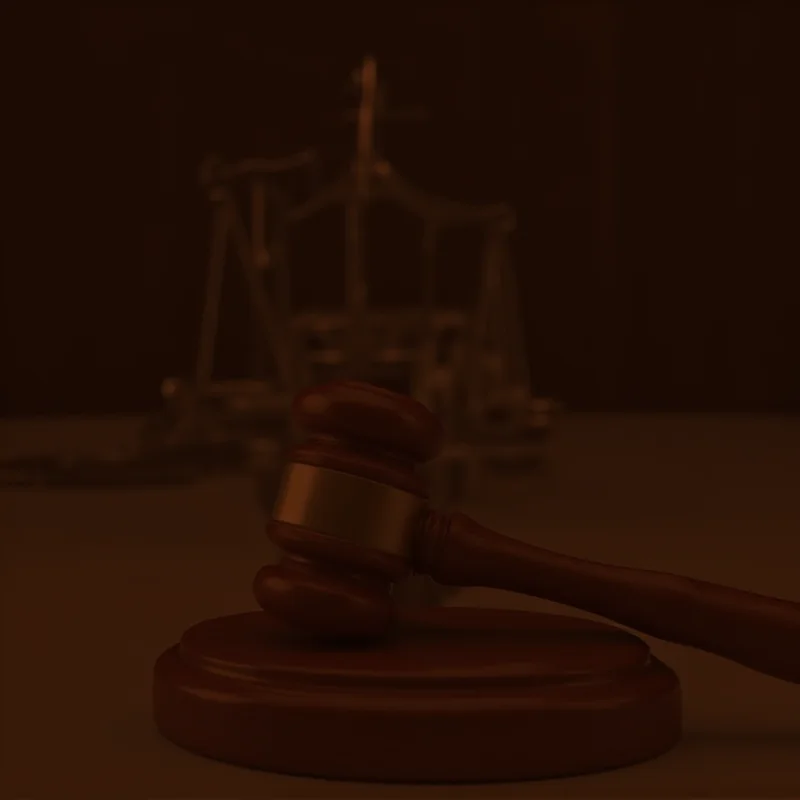 A gavel resting on a wooden sound block in a courtroom setting, symbolizing a decision being made.