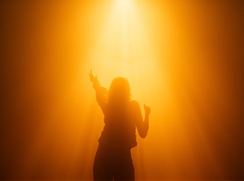 Abstract image of a person bathed in light, reaching towards a bright future, symbolizing empowerment and transformation.