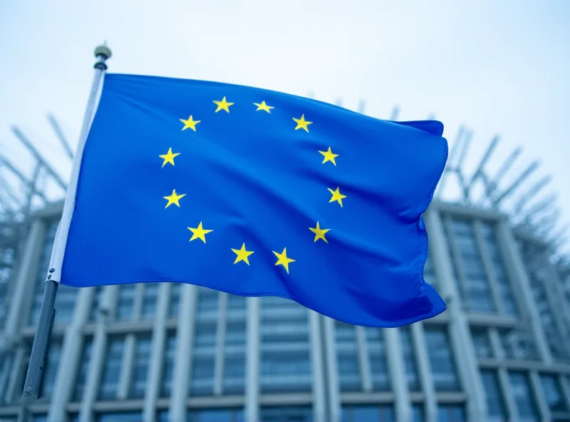 European Union flag waving in front of the European Parliament building in Brussels.