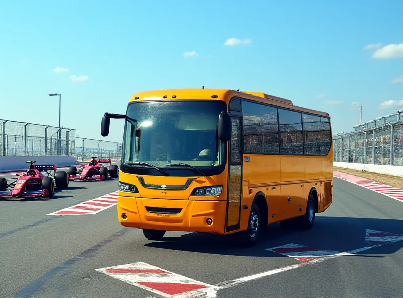 A brightly colored public bus driving on a Formula 1 race track, with F1 cars in the background, during a sunny day.