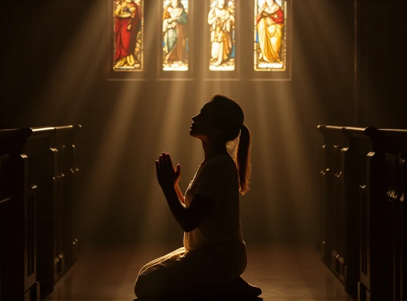 A person kneeling in prayer in a dimly lit church, bathed in soft light from a stained glass window. The atmosphere is serene and contemplative.