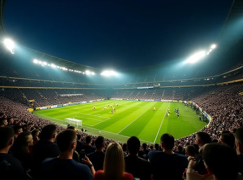 A packed soccer stadium at night, with bright lights illuminating the field. Two teams, one in black and gold, the other in yellow, are battling for possession of the ball.