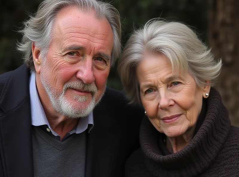 An older man standing next to a woman, both smiling gently.