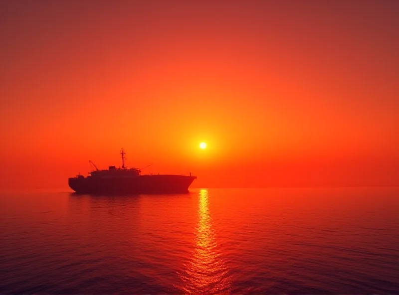 A cargo ship sailing on the ocean at sunset.