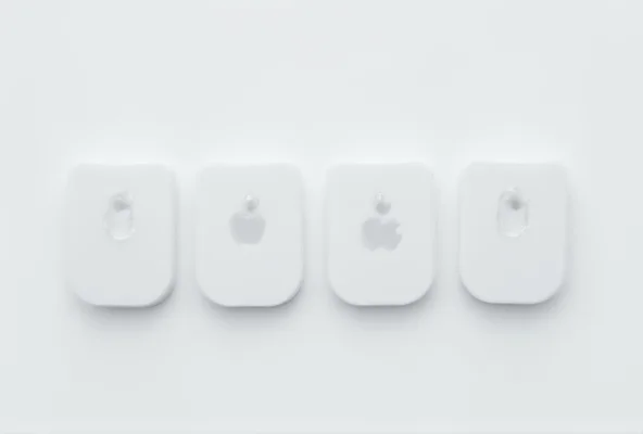 Four Apple AirTags on a white surface