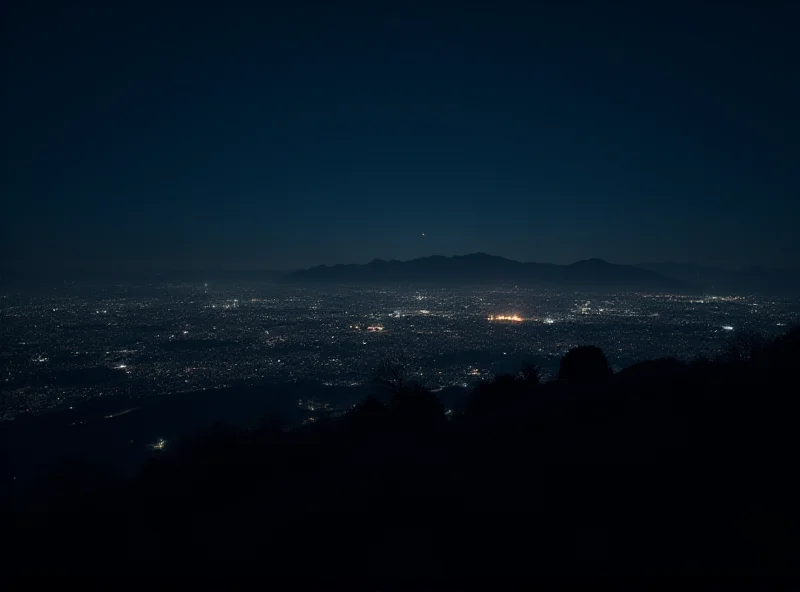 A nighttime view of Santiago, Chile, completely dark except for a few scattered lights in the distance, illustrating the scale of the blackout.