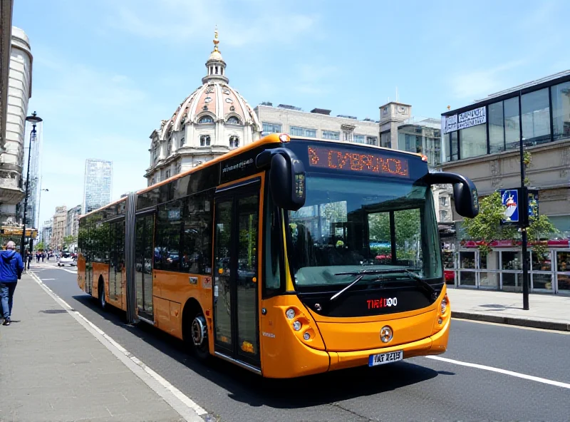 A modern bus driving down a city street in Liverpool, with iconic landmarks in the background.