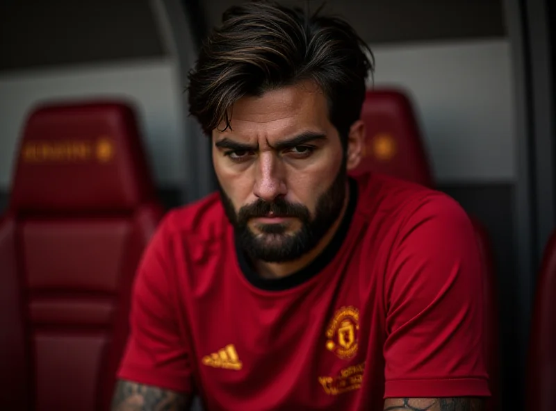 Alejandro Garnacho looking contrite on the Manchester United bench during a game. He is wearing the red Manchester United kit.