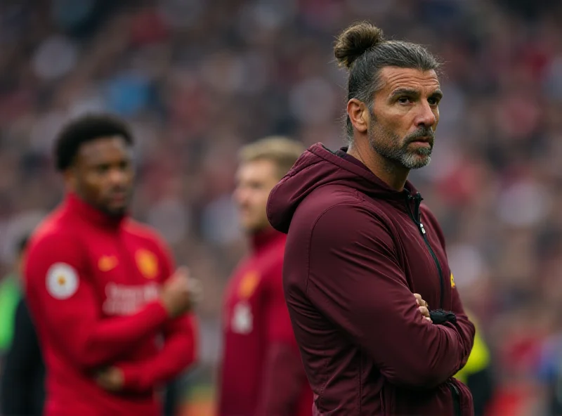 Ruben Amorim standing on the sidelines during a Manchester United match, looking concerned and thoughtful. He is wearing a Manchester United tracksuit.