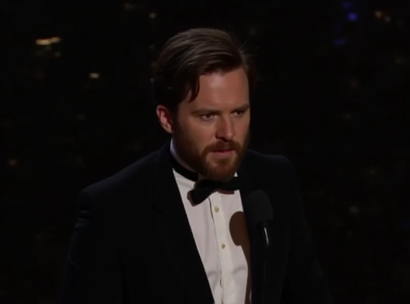 Andrew Garfield giving a speech on stage at the Oscars, looking emotional, with a spotlight shining on him.