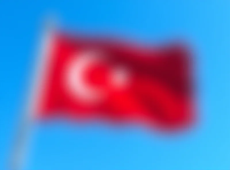 Turkish flag waving in the wind against a clear blue sky.