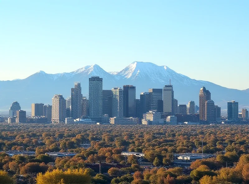 A cityscape of Denver, Colorado, with a focus on the skyline and the Rocky Mountains in the background