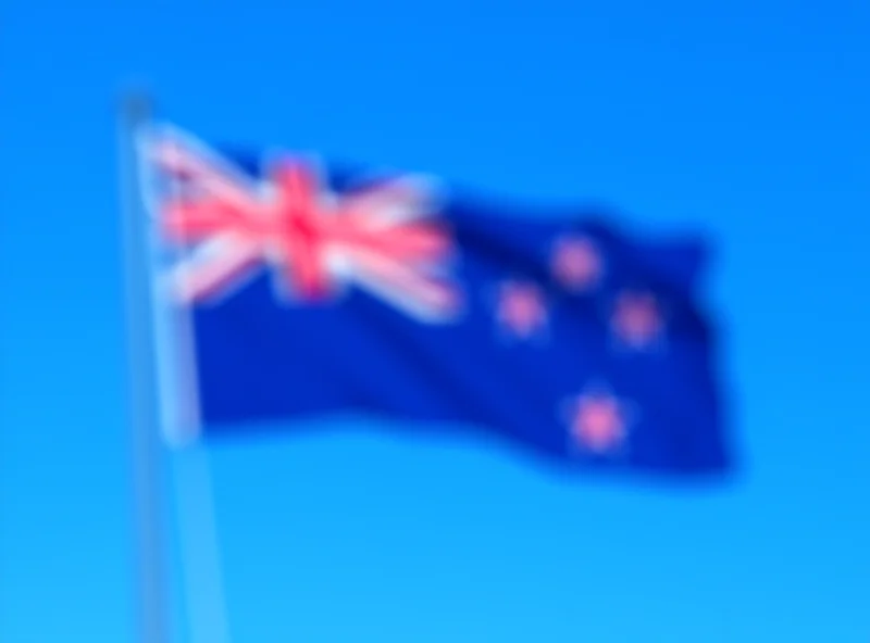 The New Zealand flag flying proudly against a blue sky.