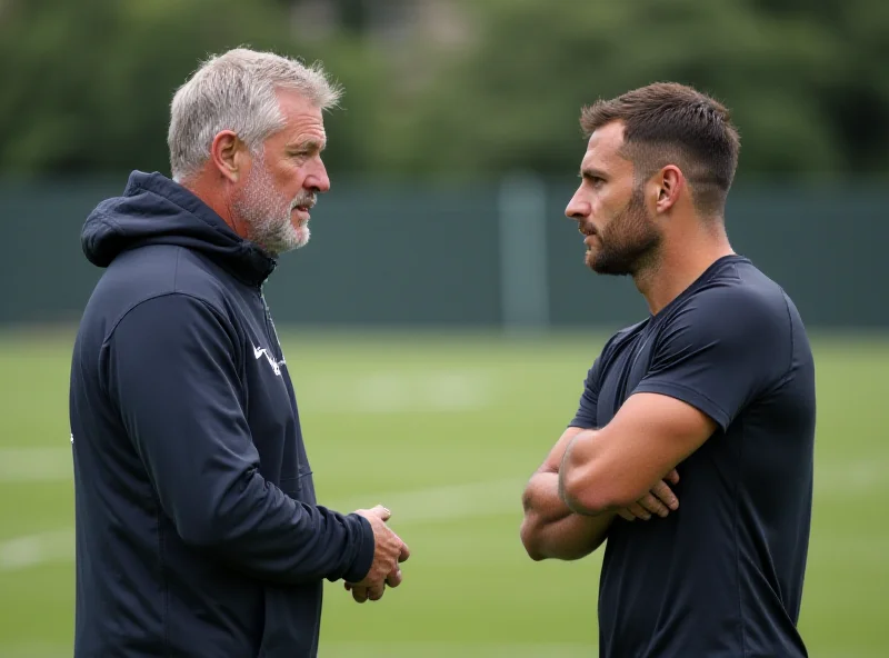 A legendary sports coach giving advice to a younger athlete on the field during a practice session.