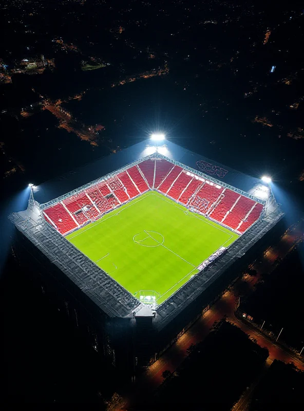 An aerial view of Anfield stadium at night, illuminated by floodlights, with a sense of grandeur and history.