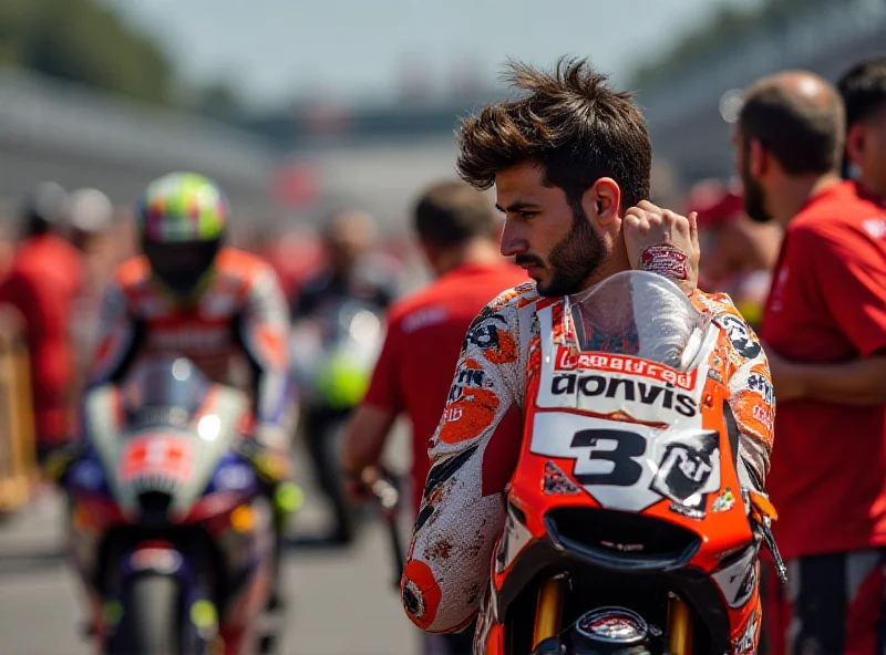 Jorge Martín in racing gear looking dejected with his left hand bandaged.