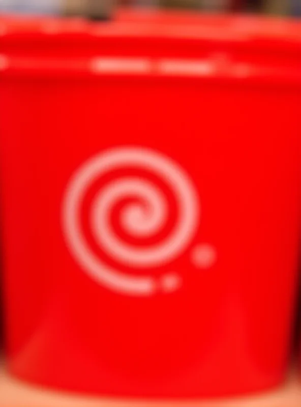 Close-up of a bright red 5-gallon plastic bucket with the Target logo on it, sitting on a shelf in a Target store.