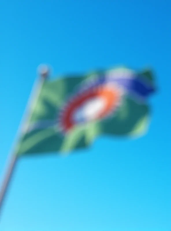 The flag of Lesotho waving gently in the wind against a clear blue sky.