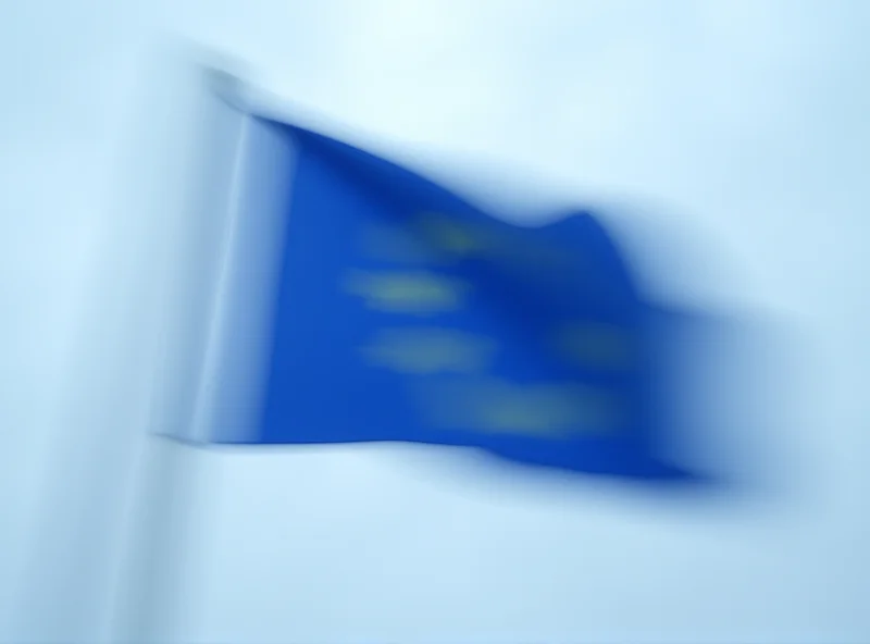 European Union flag waving in the wind against a cloudy sky.