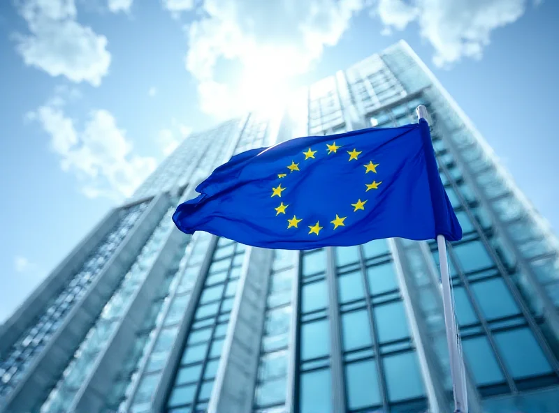 European Union flag waving in front of the EU Parliament building in Brussels.