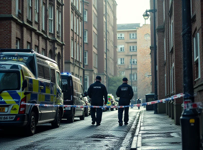 Police officers investigating a crime scene outside a high-rise apartment building in a British city.